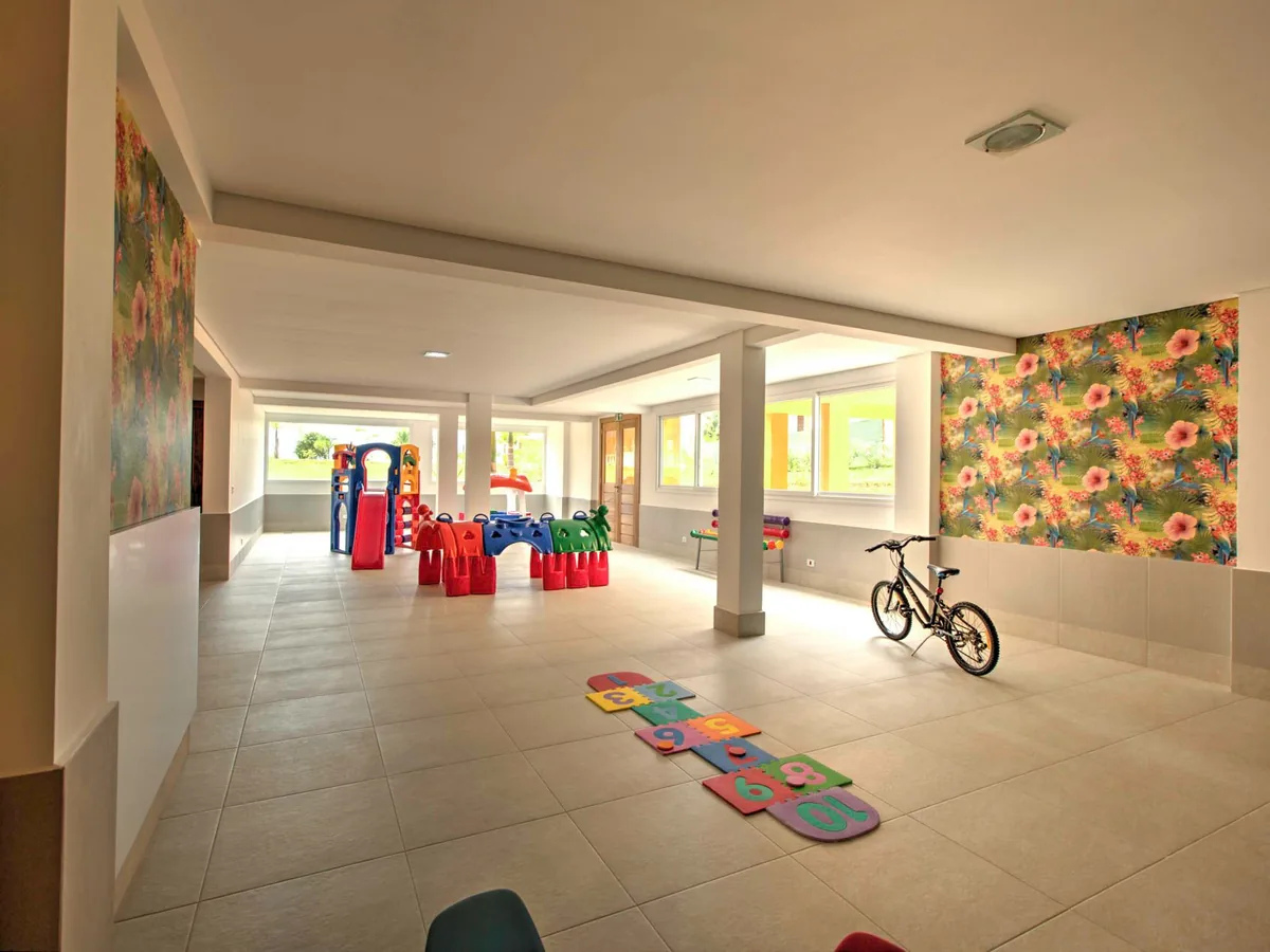 Espaço Kids do Blue Tree Daj com brinquedos, bicicleta e amarelinha no chão
