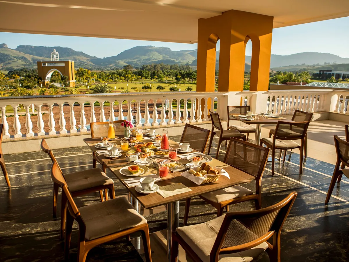 Varanda do restaurante do Blue Tree Daj com café da manhã servido e morros ao fundo