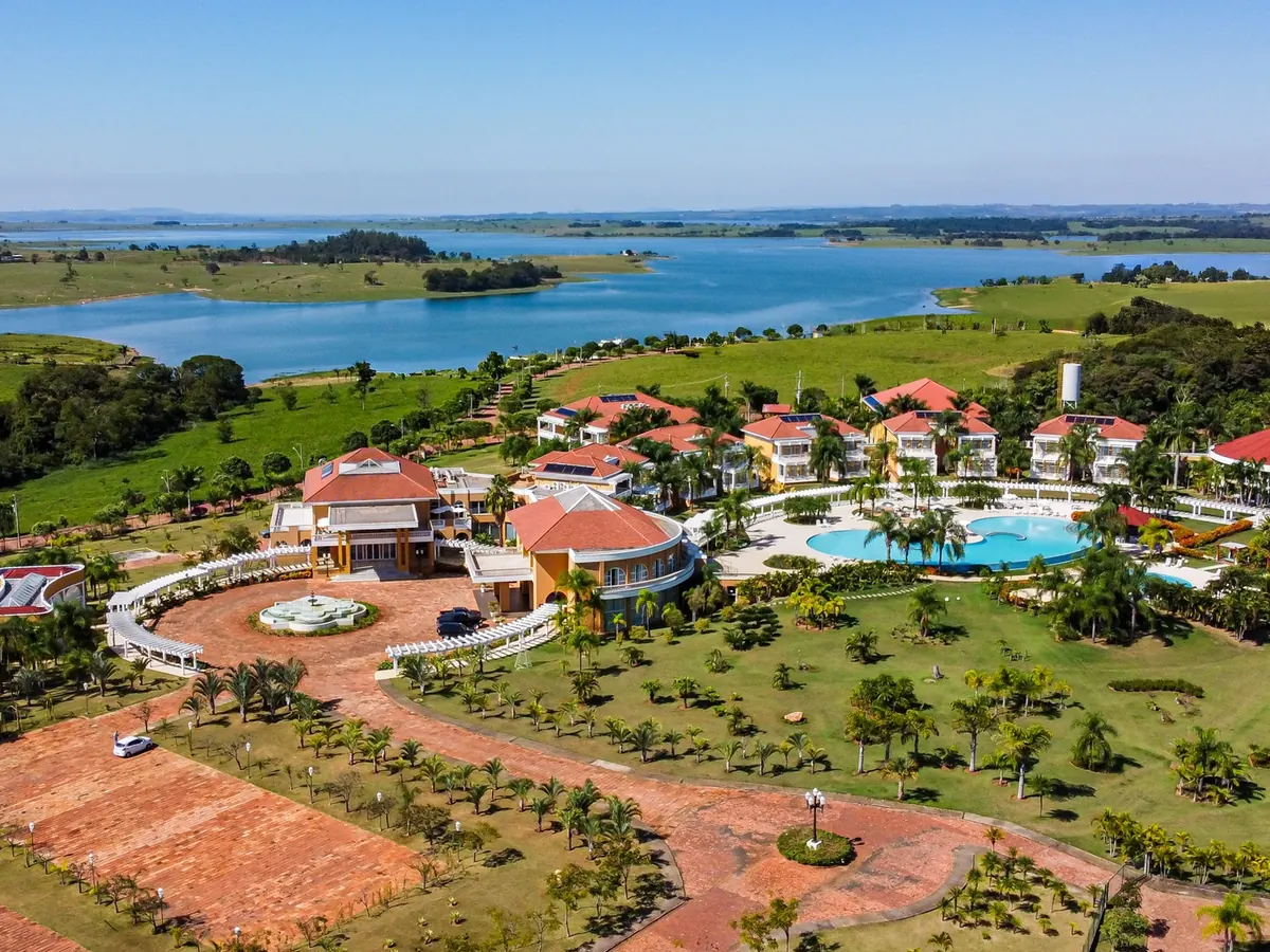 Vista aérea do Blue Tree Daj com os prédios, as piscinas e a represa de Chavantes ao fundo