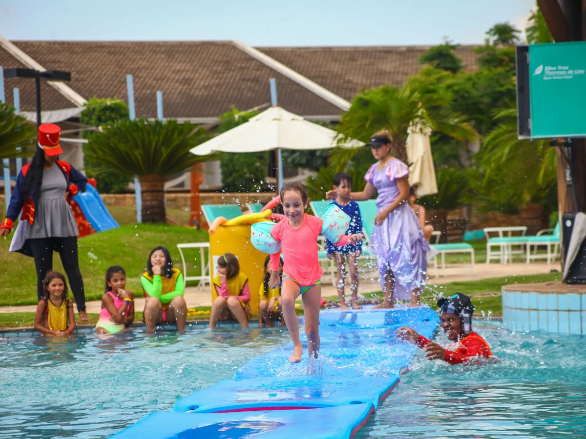Crianças atravessando a piscina sobre o tapete flutuante do Tapetão Maluco