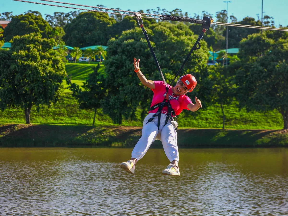 Criança descendo na tirolesa sobre o lago do Blue Tree Lins