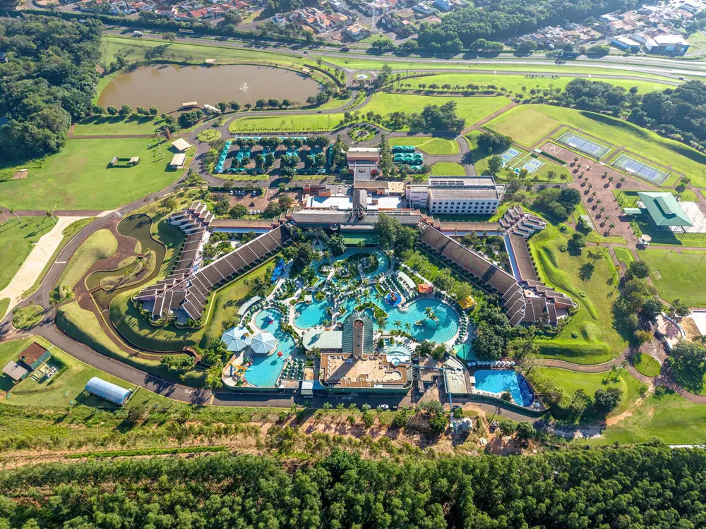 Vista aérea do Blue Tree Thermas de Lins, com o complexo de piscinas, as alas de apartamentos e o lago