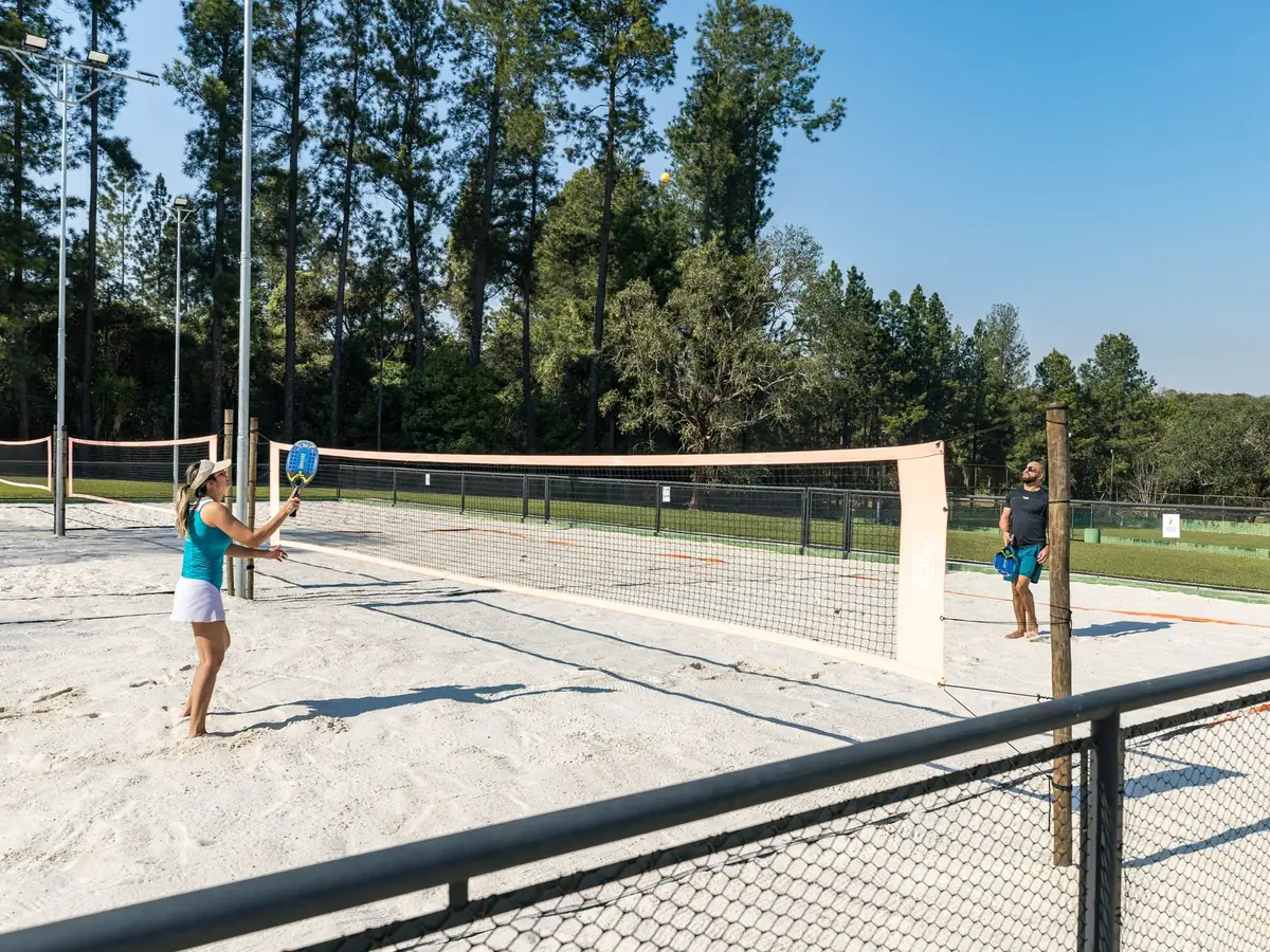 Hóspedes jogando beach tennis na quadra de areia do Vale das Águas